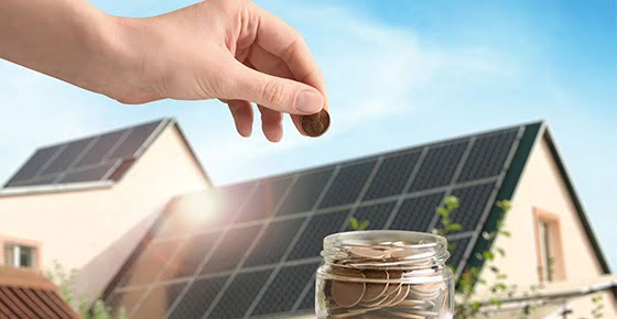 Money putting into a box with a house in the backgroud - commercial solar