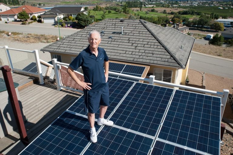 old man standing on the solar panels rooftop - solar consultation, solar consultation services